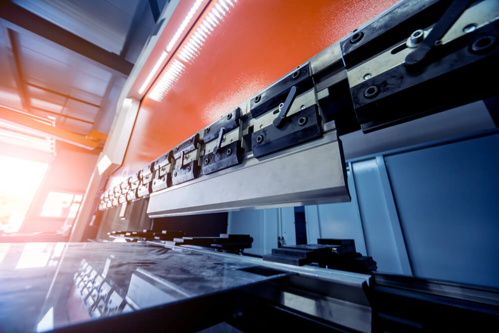 Prasa krawędziowa do gięcia blachy w nowoczesnej hali produkcyjnej, zbliżenie na matrycę i stół