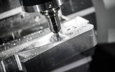 Frezarka CNC obrabiająca metalową płytę, widoczny narzędzie i wióry.